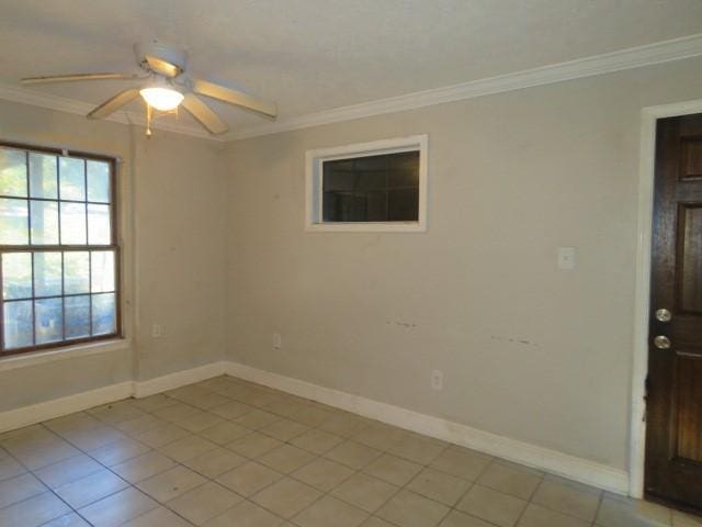 empty room featuring ceiling fan, ornamental molding, and light tile patterned flooring