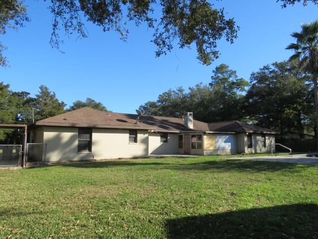 rear view of house featuring a yard