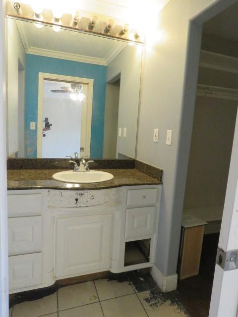 bathroom featuring tile patterned flooring, vanity, and crown molding