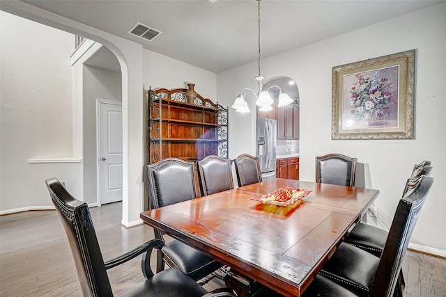 dining room with a chandelier and light wood-type flooring