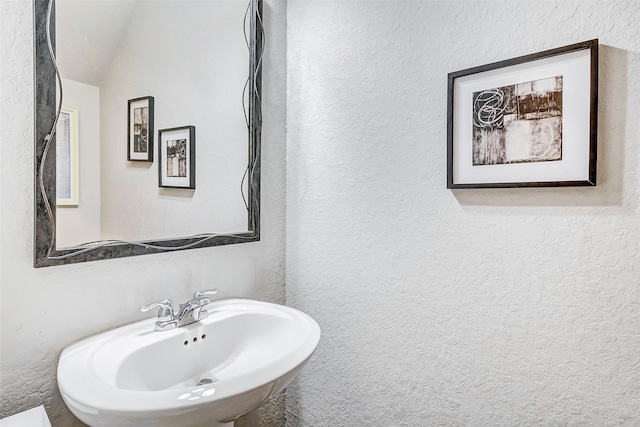 bathroom featuring sink and vaulted ceiling