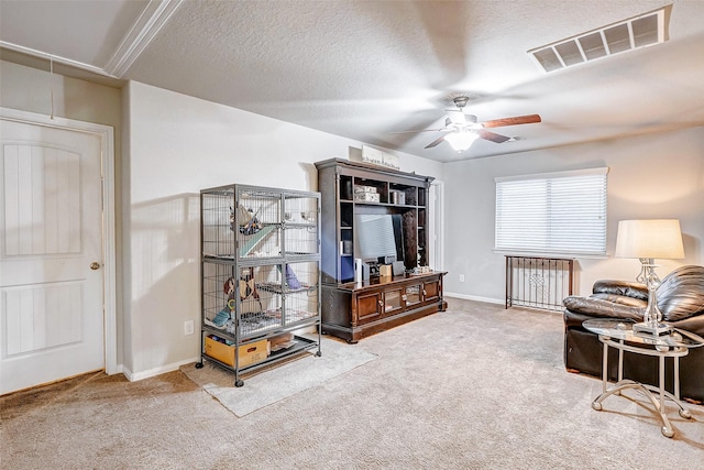 carpeted living room featuring ceiling fan and a textured ceiling