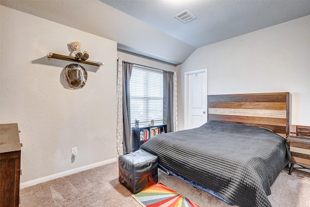 carpeted bedroom with a textured ceiling and vaulted ceiling