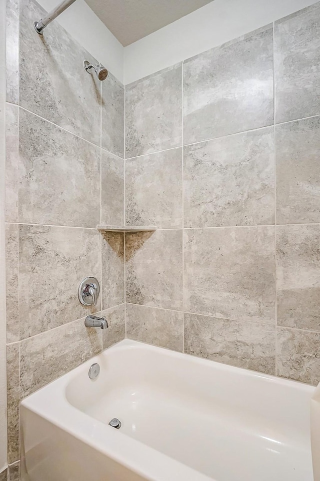 bathroom featuring tiled shower / bath