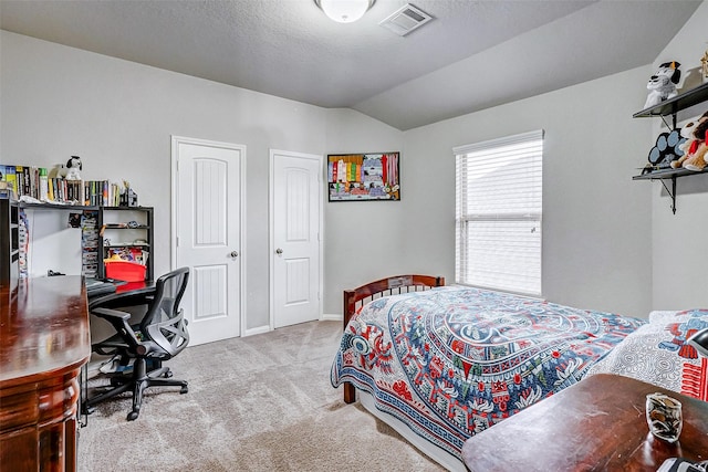 bedroom featuring vaulted ceiling, a textured ceiling, and light colored carpet