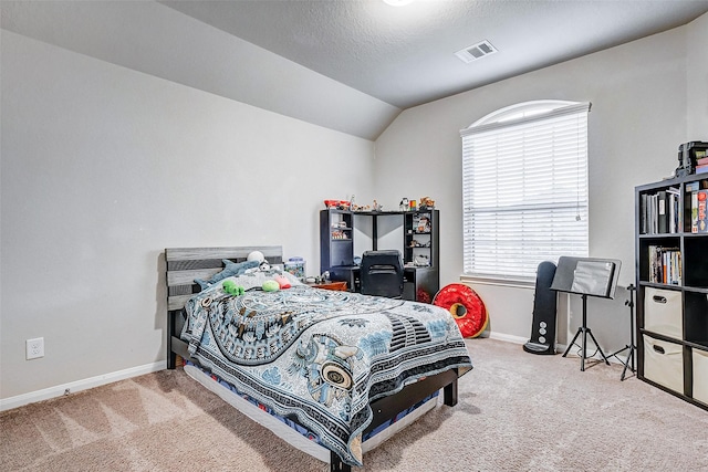 carpeted bedroom with a textured ceiling and lofted ceiling