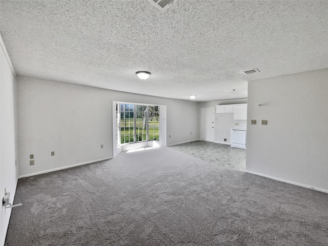 carpeted empty room featuring a textured ceiling