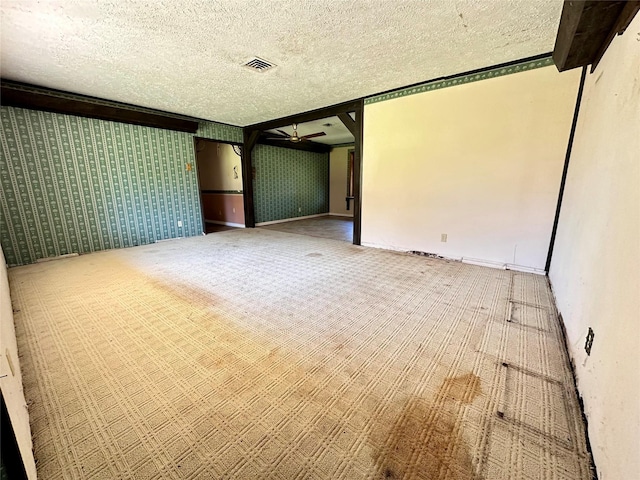 unfurnished room with a textured ceiling, carpet floors, and ceiling fan