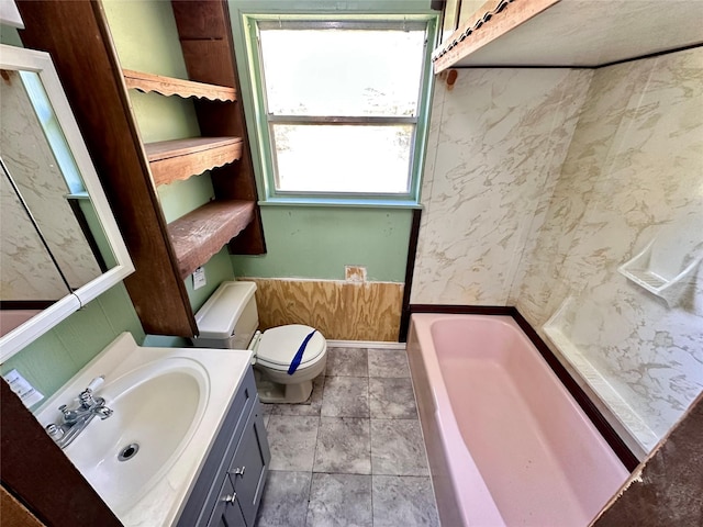 bathroom with vanity, a bath, and toilet