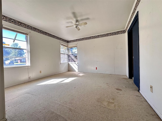 carpeted spare room with ceiling fan