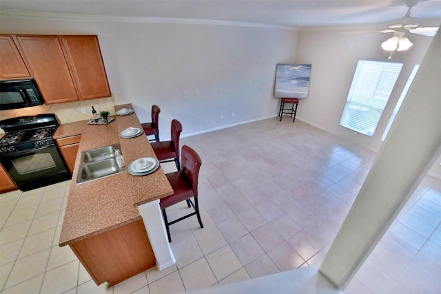 kitchen with sink, tasteful backsplash, crown molding, light tile patterned floors, and black appliances