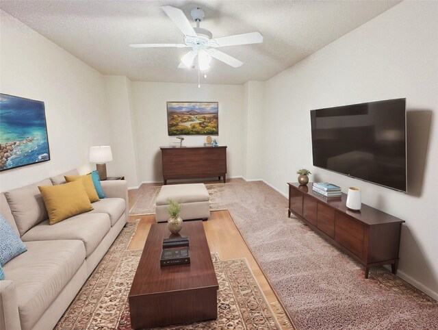 living room featuring a textured ceiling and ceiling fan