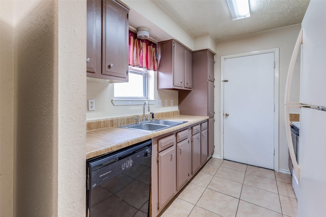 kitchen featuring sink, light tile patterned floors, and black dishwasher