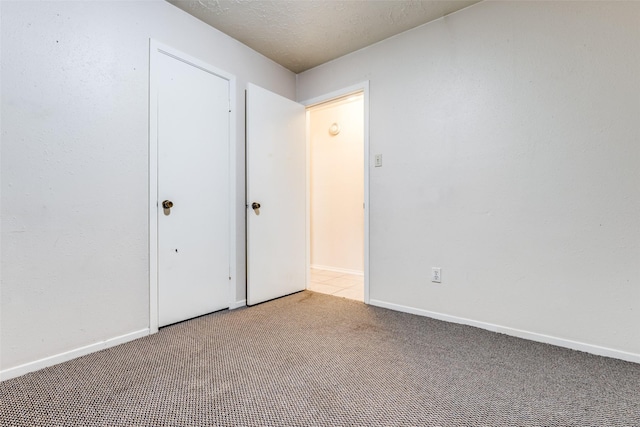 unfurnished bedroom featuring light carpet and a textured ceiling