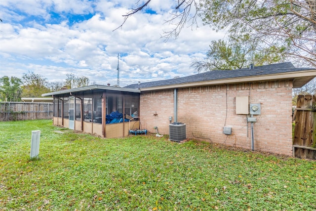 exterior space featuring a yard, central AC unit, and a sunroom