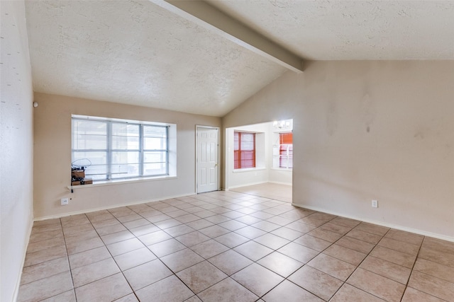 unfurnished room with light tile patterned floors, a textured ceiling, lofted ceiling with beams, and plenty of natural light