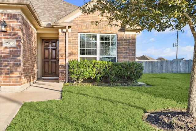 view of exterior entry featuring a yard