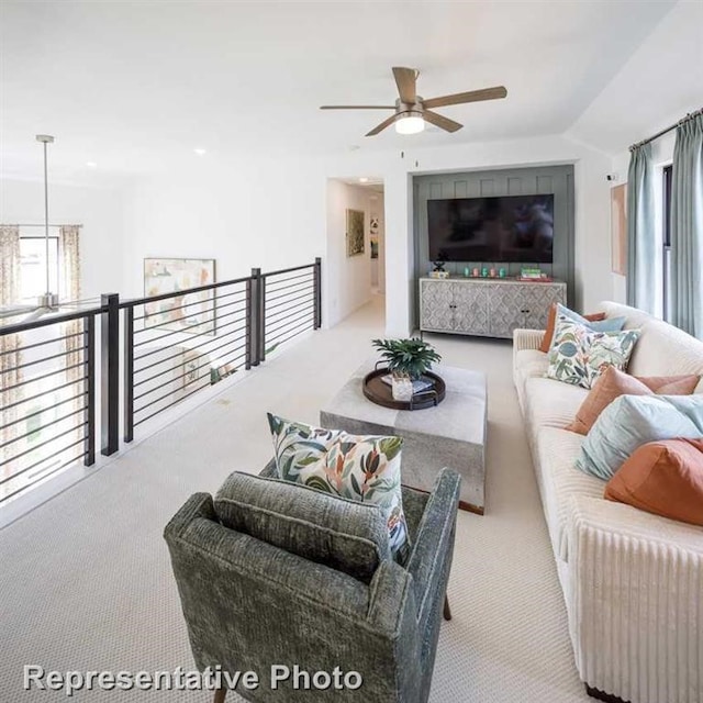 carpeted living room with ceiling fan and lofted ceiling