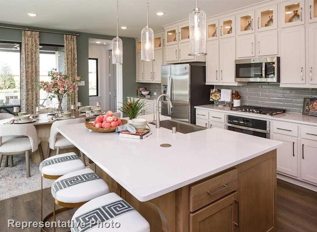 kitchen featuring a breakfast bar area, sink, an island with sink, and appliances with stainless steel finishes