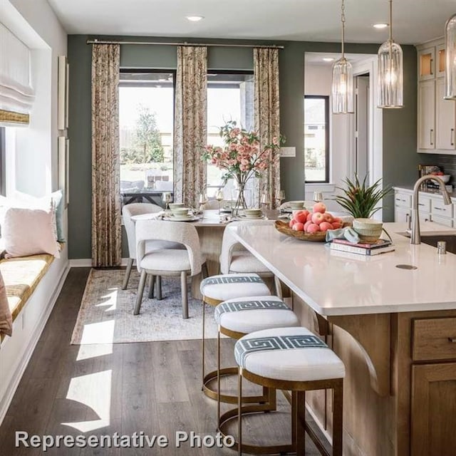 dining area with sink, dark hardwood / wood-style floors, and an inviting chandelier