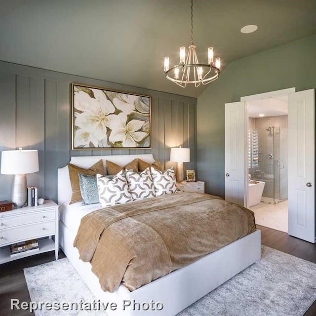 bedroom featuring ensuite bath, a chandelier, lofted ceiling, and hardwood / wood-style flooring