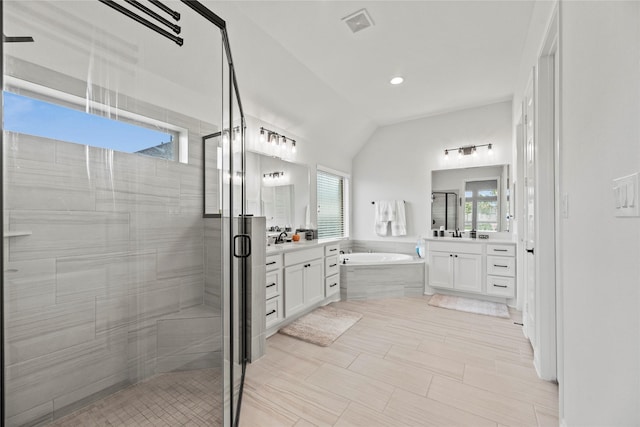 bathroom featuring plenty of natural light, vanity, independent shower and bath, and vaulted ceiling