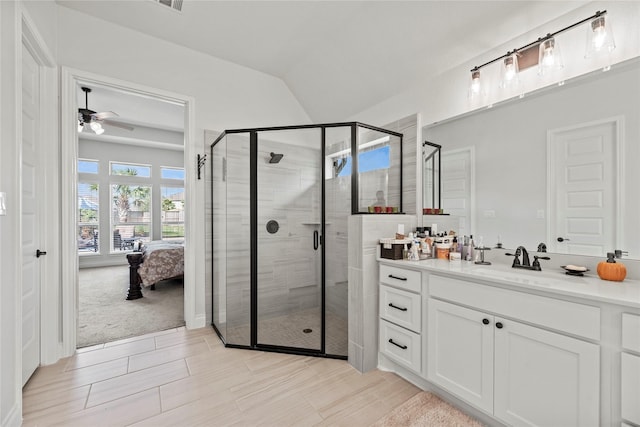 bathroom with ceiling fan, lofted ceiling, walk in shower, and vanity