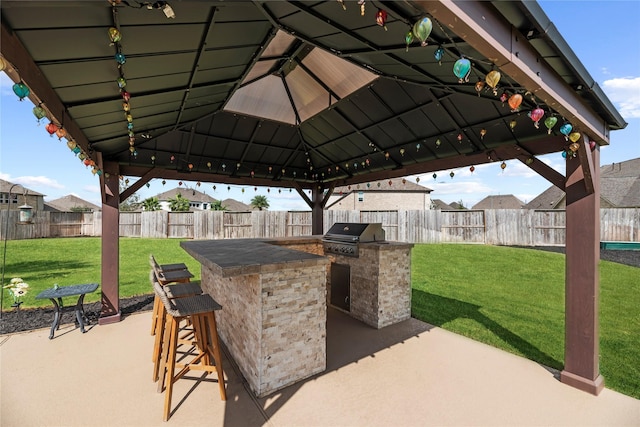 view of patio with a gazebo, a grill, exterior bar, and an outdoor kitchen