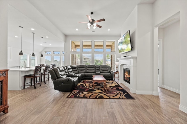 living room with light hardwood / wood-style floors and ceiling fan