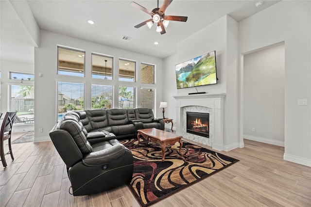 living room featuring ceiling fan and a high end fireplace