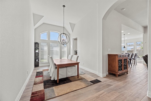 dining space with light hardwood / wood-style floors and a notable chandelier