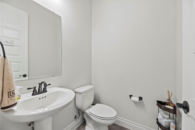 bathroom featuring hardwood / wood-style flooring, toilet, and sink