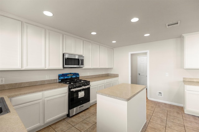 kitchen with white cabinets, light tile patterned floors, a center island, and stainless steel appliances