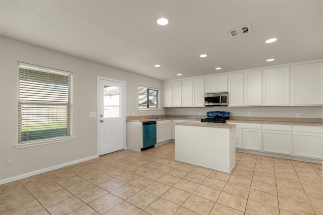 kitchen featuring white cabinets, sink, a kitchen island, appliances with stainless steel finishes, and light tile patterned flooring