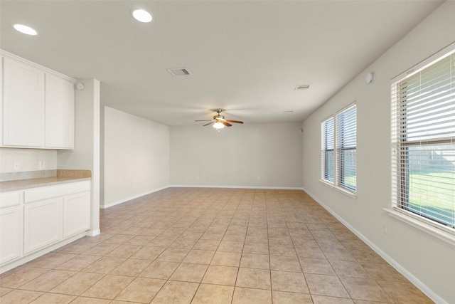 unfurnished living room featuring ceiling fan and light tile patterned floors