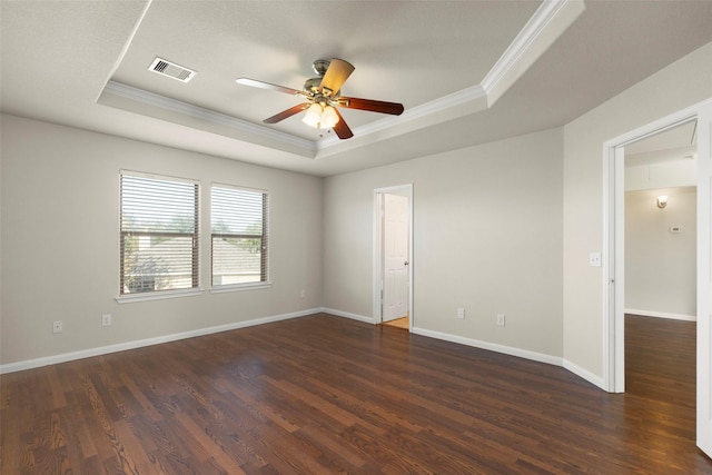 spare room featuring a tray ceiling, ceiling fan, crown molding, and dark hardwood / wood-style floors