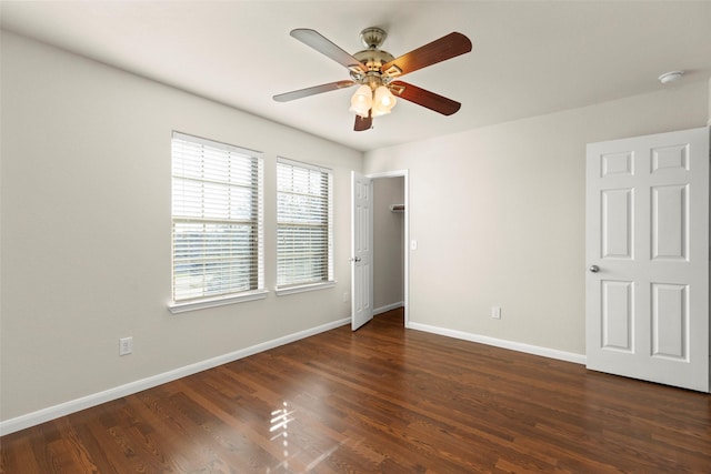 unfurnished bedroom with multiple windows, ceiling fan, and dark wood-type flooring