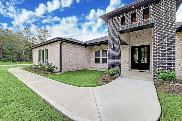 property entrance with a lawn and a balcony