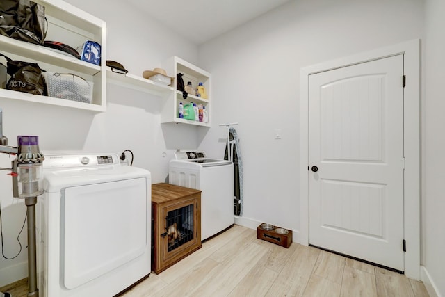 clothes washing area featuring washer and dryer and light wood-type flooring