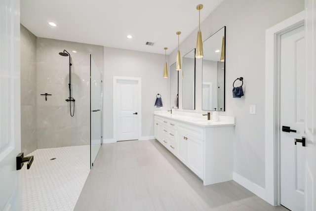 bathroom with vanity and tiled shower