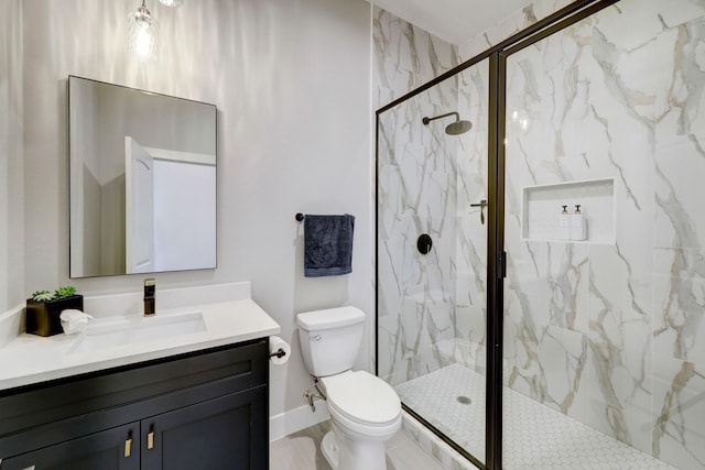 bathroom featuring vanity, a shower with shower door, and toilet