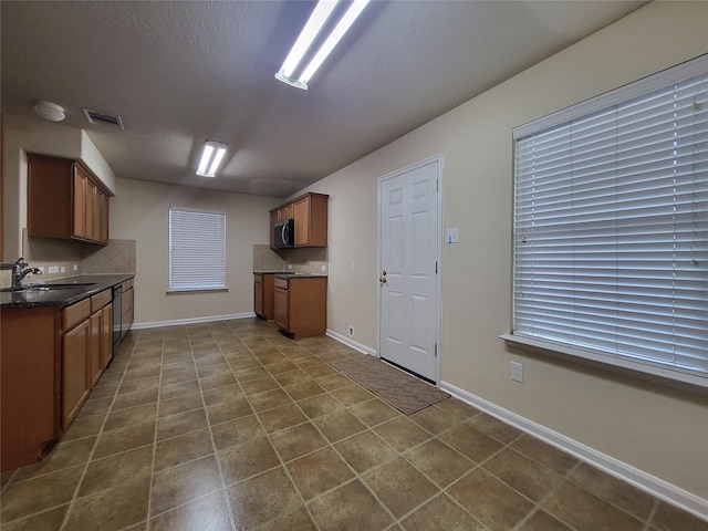 kitchen with sink, a textured ceiling, and black dishwasher