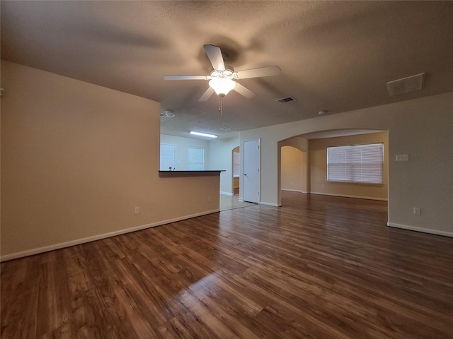 unfurnished room with ceiling fan, dark wood-type flooring, and a textured ceiling