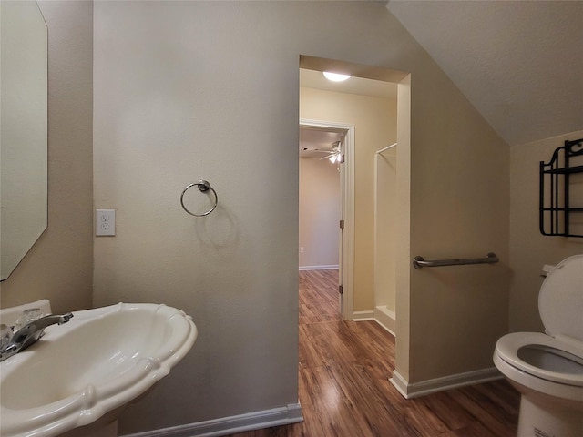 bathroom with a textured ceiling, vaulted ceiling, sink, hardwood / wood-style flooring, and toilet