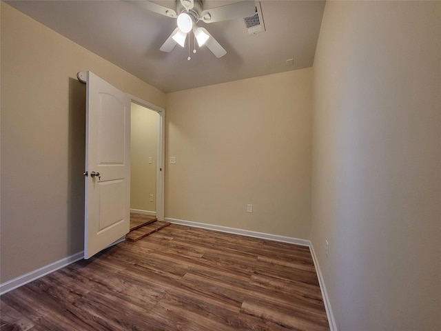 unfurnished room with ceiling fan and dark wood-type flooring