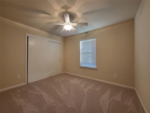 unfurnished bedroom featuring ceiling fan, a closet, and carpet floors