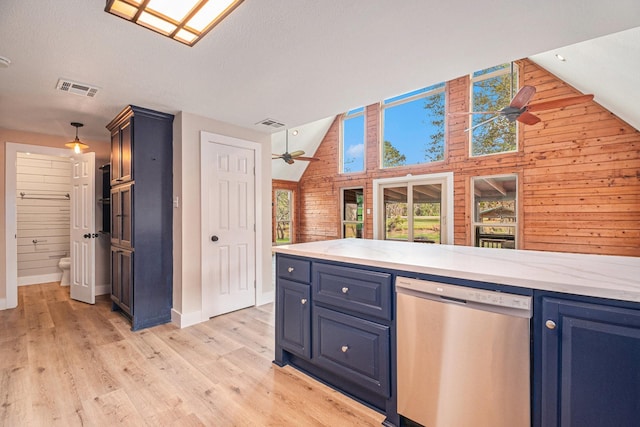 kitchen with wood walls, blue cabinets, hanging light fixtures, stainless steel dishwasher, and ceiling fan