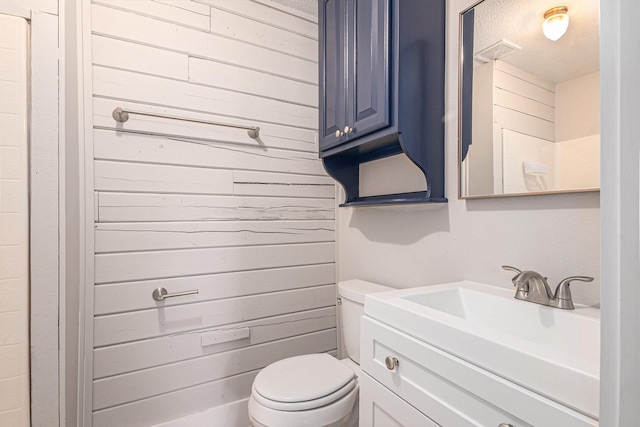 bathroom with vanity, a textured ceiling, and toilet