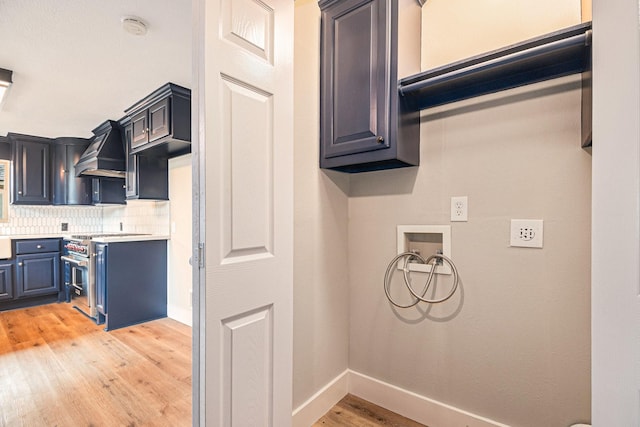 clothes washing area featuring washer hookup, cabinets, and light hardwood / wood-style floors