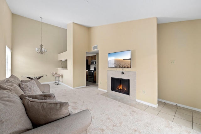 tiled living room with a tile fireplace and a chandelier